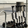 A row of bird scooters parked near a bike rack.