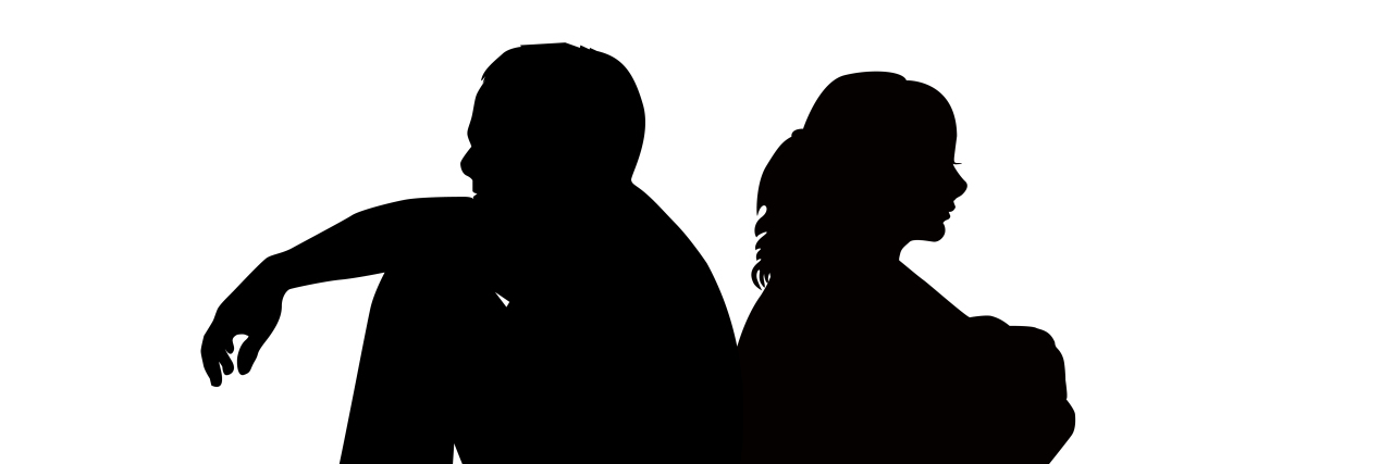 Silhouettes of sad couple sitting back to back