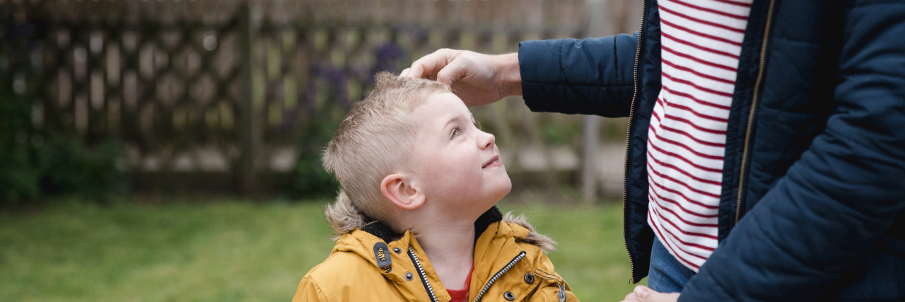 How I Respond When Kids Ask About My Walking Stick and Fibromyalgia woman standing outside with her son, who is smiling up at her.