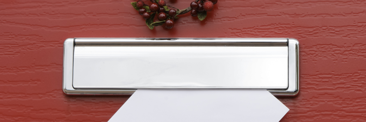 Responding to a Neighbor Who Complained About My Crying Red door with wreath and letter in mail slot.