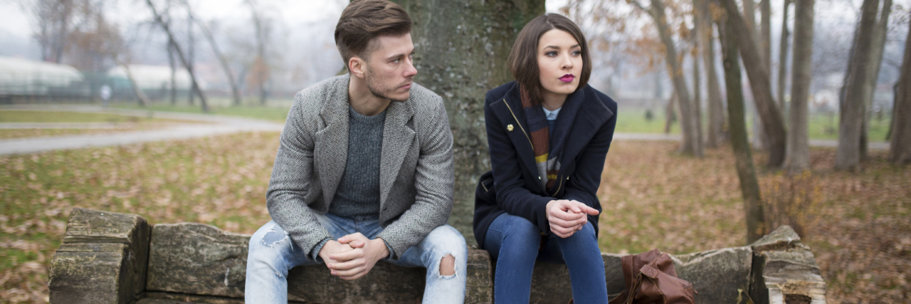 When We Fight With Our Lovers, Can a Relationship Counselor Help? Young couple sitting on the bench in the park, having relationship difficulties.