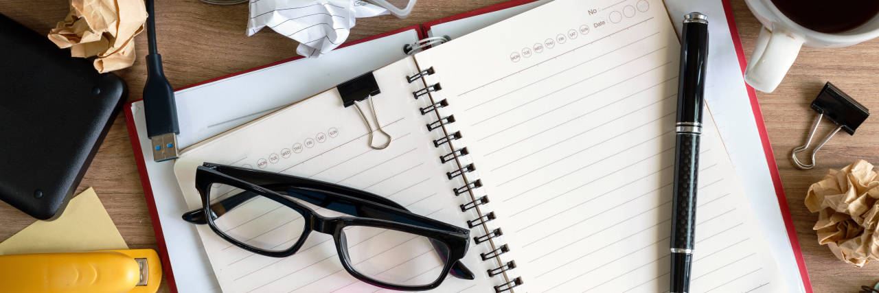 Being a 'Smart Girl' With Undiagnosed ADHD Messy desk with glasses, pen, papers.