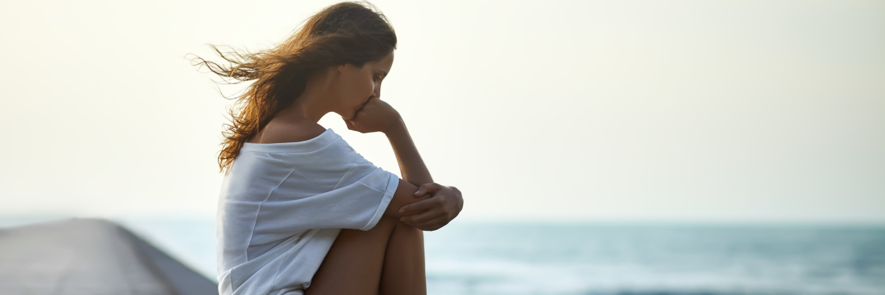 What It Was Like Losing My Mother Unexpectedly a sad woman sitting alone on the pier