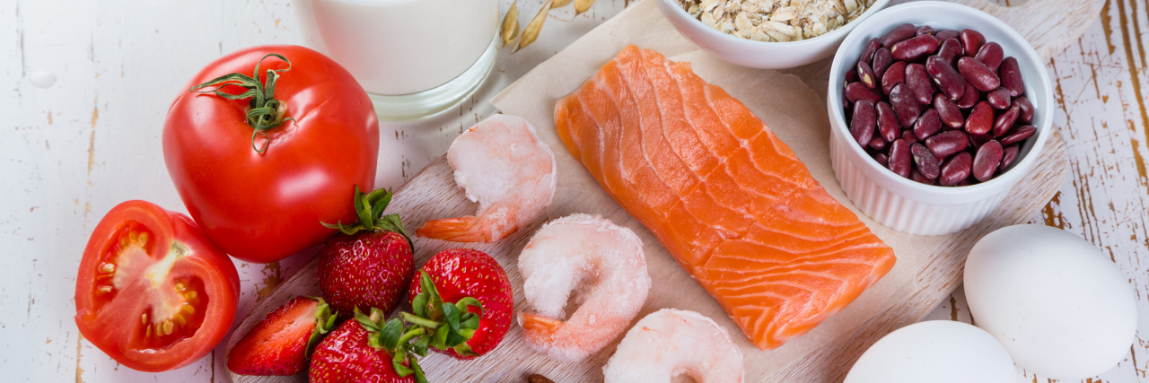 Only Half of People Who Think They Have Food Allergies Do, Study Says major allergens on a table. includes nuts, strawberries, tomatoes, milk, shrimp, fish, eggs, beans, oats