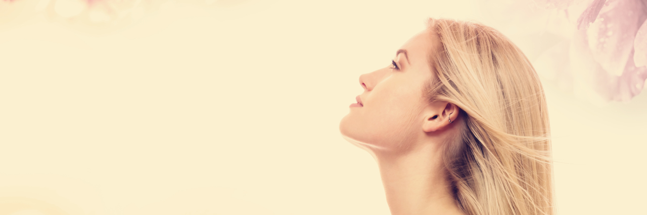 Continuing to Shine With a Disability in the New Year Young woman on a pink floral background.