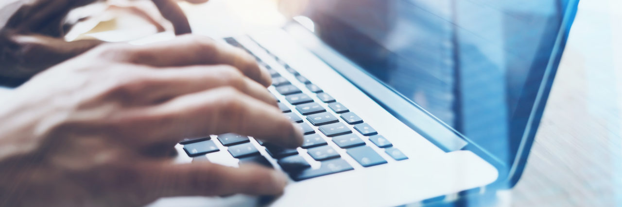 Finding a Career as an Autistic Person Man typing on laptop computer, closeup view.