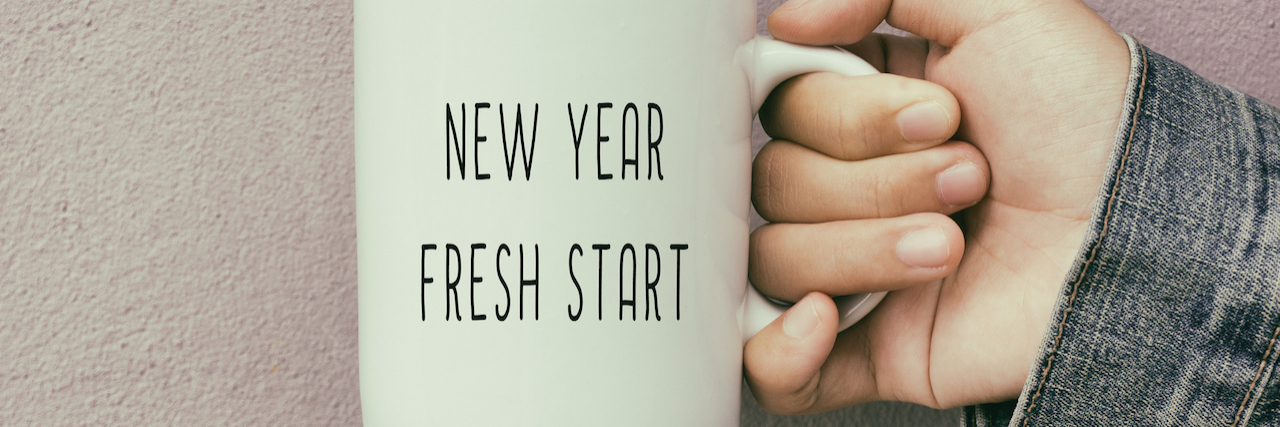 How to Make a New Year's Resolution With a Mental Illness Hands Holding a Coffee Mug With Text New Year Fresh Start