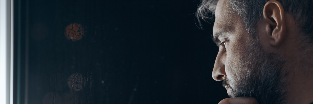 How I've Learned to Grow After the Trauma of My Grandma's Death Man holding chin beside window