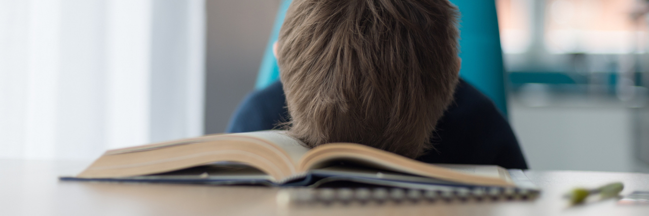 Schools Need to Provide Better Support for Kids on the Autism Spectrum Boy resting head on open book
