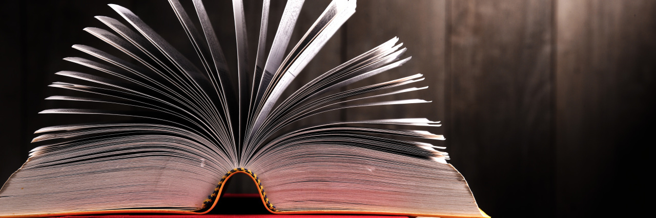 Using Appropriate Language to Talk About Autism Open dictionary on pile of books.