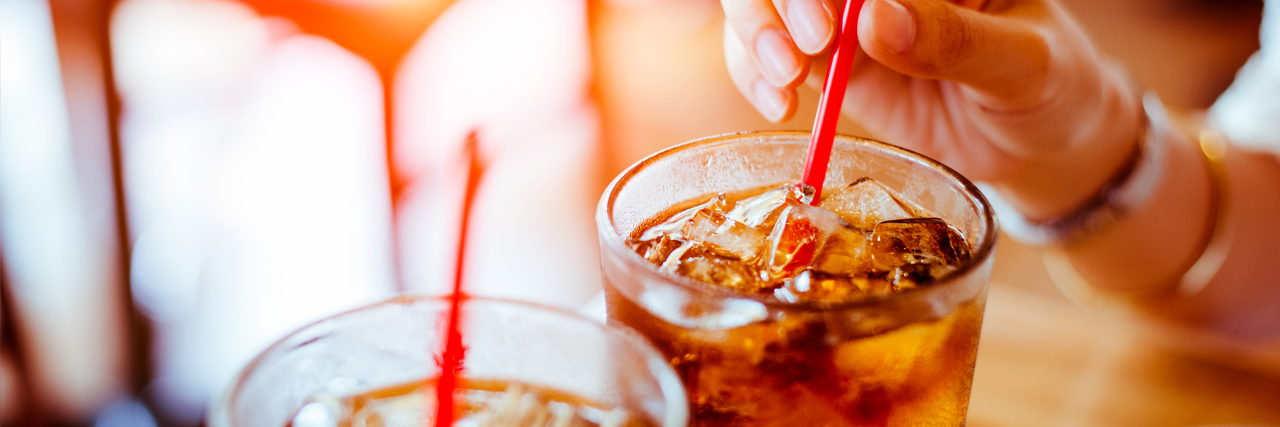 Bipolar Disorder, , mental health, bipolar 1How Caffeine in Soda Affected My Bipolar Mania close up of two glasses of soda with straws and woman's hand