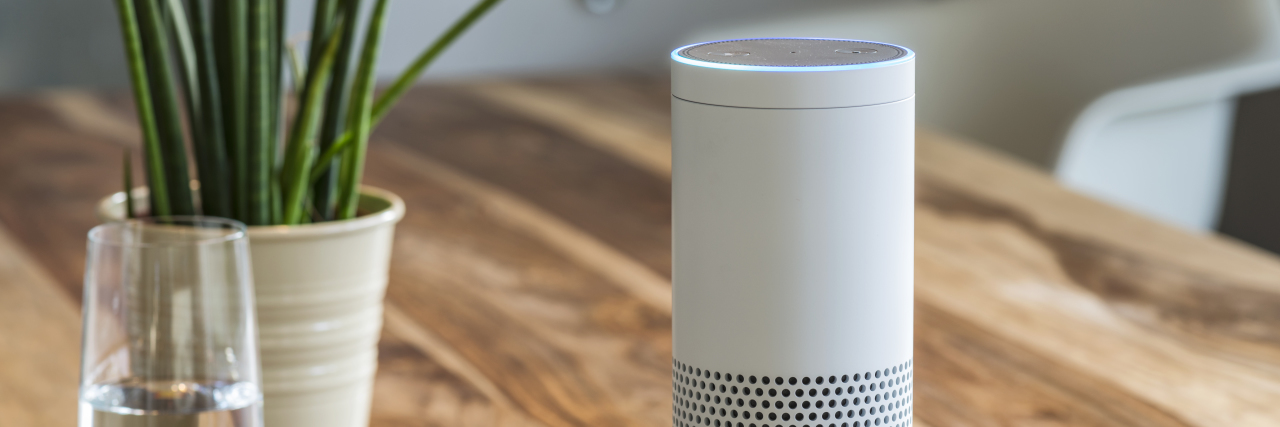 Amazon Echo speaker sitting on wooden table.