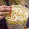 Woman's hand close up, picking up popcorn.