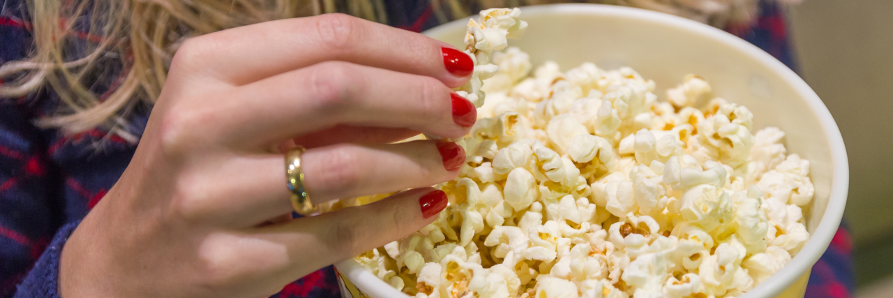 Going Out Alone as a Person With a Disability Woman's hand close up, picking up popcorn.