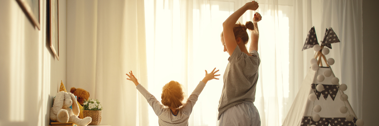 How to Be a Mom While Grieving a Suicide mother and child daughter stretch themselves after waking up in the morning