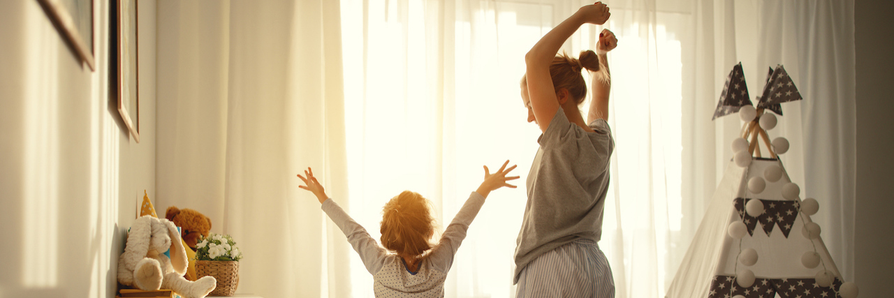 mother and child daughter stretch themselves after waking up in the morning
