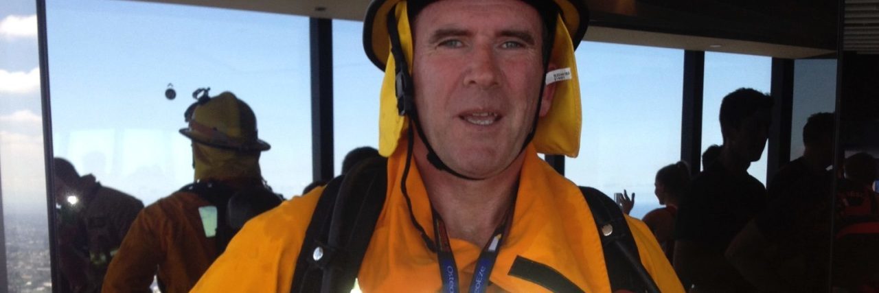 How I Rescued My Inner Child as a Volunteer Firefighter With PTSD photo showing 50-year-old man in volunteer firefighter uniform with charity number on his chest looking tired