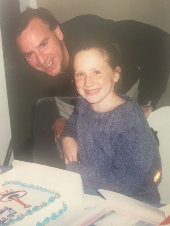 dad and daughter on her birthday in front of a cake