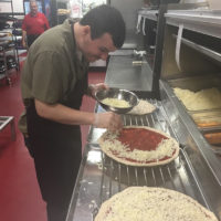 Nicole's brother making pizza at work.