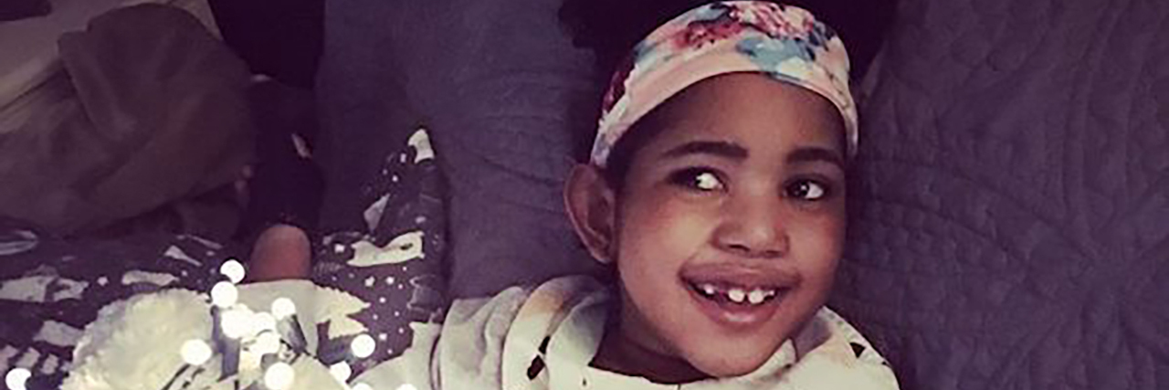 Staying Positive When Parenting a Medically Complex Child Shelly's daughter sitting on the couch with flowers near her.