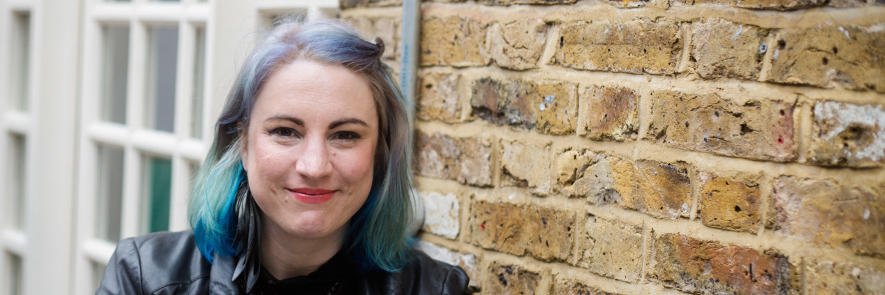 Chronic Pain and the Procrastination Myth Jo sitting at a cafe with her laptop.