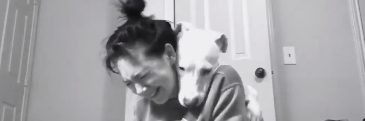 Viral Twitter Video Shows Pitbull Consoling Her Mom With Depression Black and white photo of Emma crying with Luna resting her head on her shoulder.