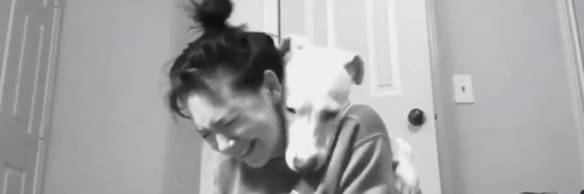 Black and white photo of Emma crying with Luna resting her head on her shoulder.