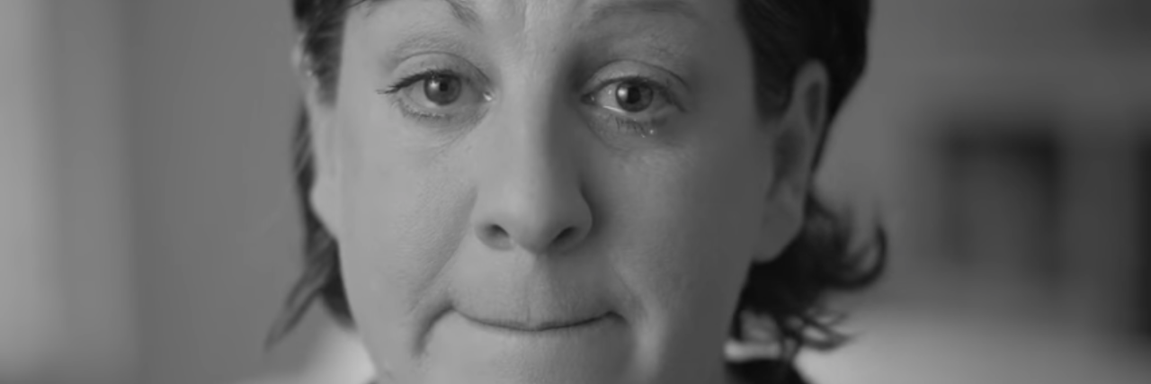 screenshot from cannabis ad. it's a black and white image of a woman crying