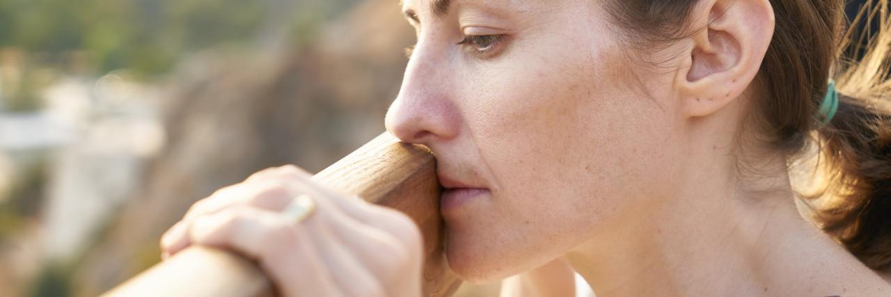 When You Don't Want to Live, but You Don't Want to Die photo of sad woman resting against fence looking over edge