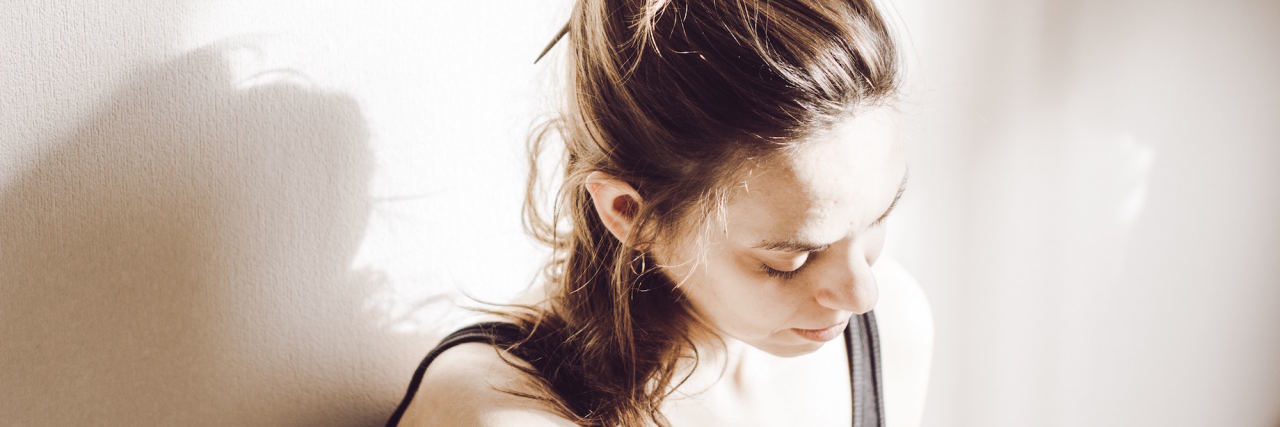 4 of the Worst Things Professionals Have Told Me as Someone With BPD woman sitting in corner with her head down