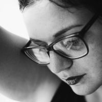 close up black and white portrait photo of woman wearing glasses
