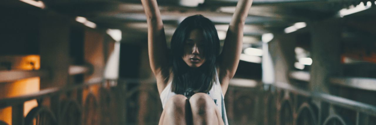 The Only Women's Mental Heath Support Group in Taiwan young woman in taiwan pulling herself up on roof of bridge or walkway fitness