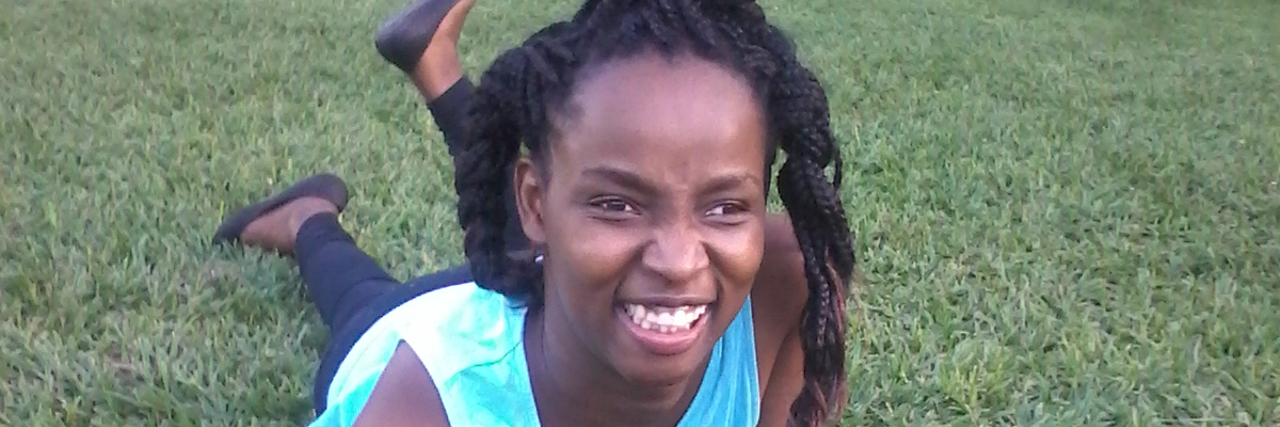 Dear Cerebral Palsy, You've Taught Me So Much Elsa Wangui, teen girl lying in the grass outdoors.