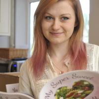 photo of nicola davis posing with her eating disorder recovery cookbook