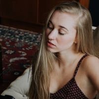 photo of young blonde woman sitting on couch with eyes closed