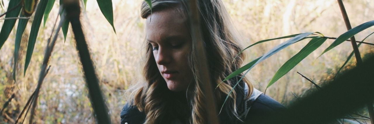 Why Someone Would Say They Want to Die by Suicide blonde woman standing on woods in shade of trees