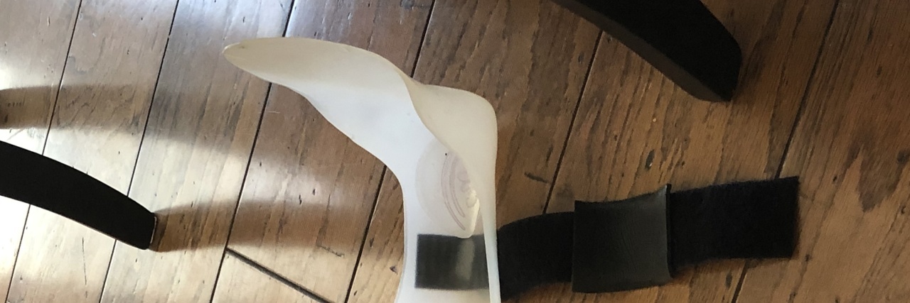 When You're Tired of Living With Multiple Sclerosis lower leg brace lying on a wooden floor