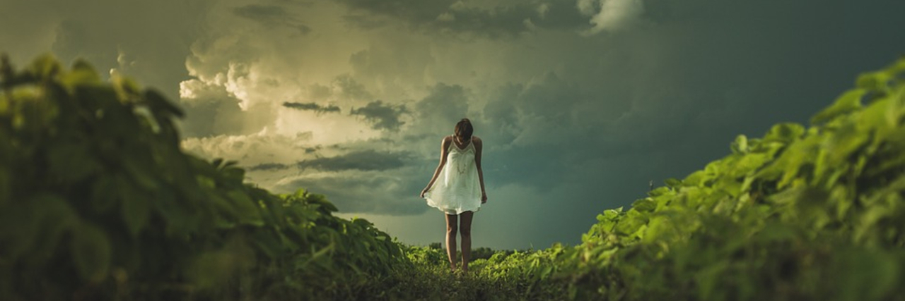Fighting the Fear of Disability Woman on a hillside looking down at her feet.