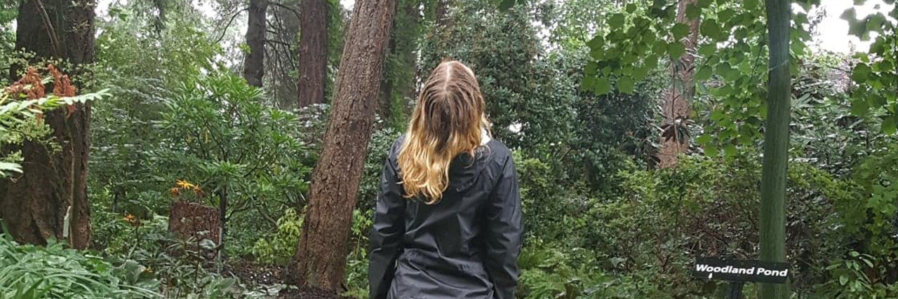 Kayla walking on a forest trail.