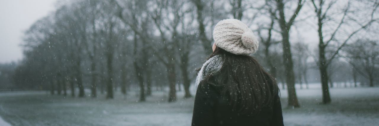 How to Help a Loved One Through a Bad Patch of Depression photo of woman in winter wearing hat and walking through bare trees and frosty ground