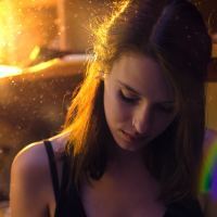 photo of young woman in golden sunlight with rainbow light flare