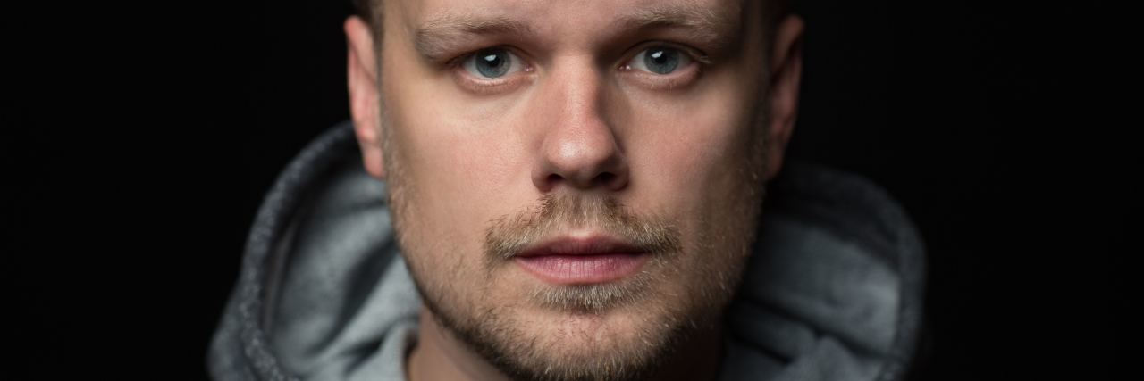 I Feel Ashamed of My Mental Health Hospitalization photo of man with beard and short styled hair looking into camera with sad eyes