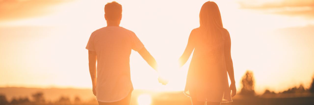 The 'Key' to a Relationship When You Live With BPD photo of couple standing hand in hand watching sunset together