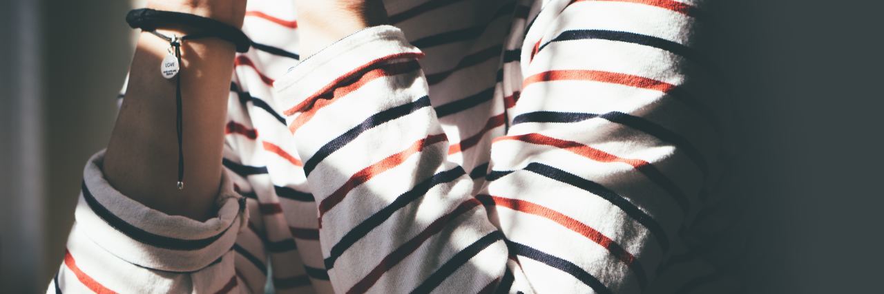 Depression Makes Me Miss the Person I Used to Be close up of woman's elbows leaning on table bathed in light from sunrise