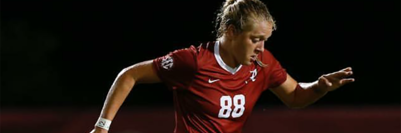 Playing Division 1 College Soccer as a Girl on the Autism Spectrum Lacey wearing her University of Alabama uniform, kicking a soccer ball.