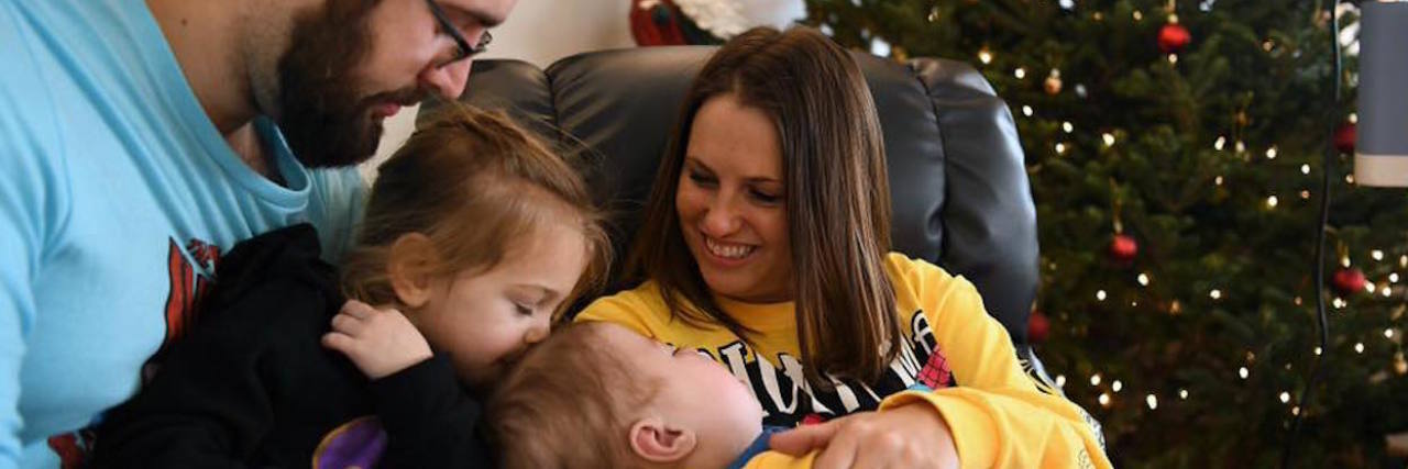 Feeling Lonely as the Parent of a Child With a Disability The author smiling with her kids and partner.