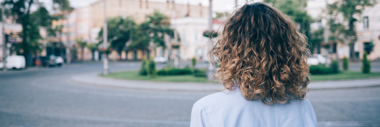 How to 'Stay Active' When You Live With a Chronic Illness A woman walking on the street, facing away