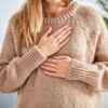 close up photo of woman with hands to chest
