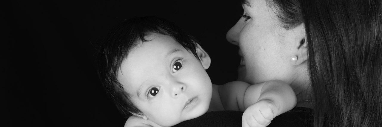 Parenting Disabled Children With a Disability Mother holding her baby who is looking over her shoulder.