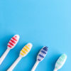 Four colorful toothbrushes on blue. Group of y toothbrushes on a blue background.